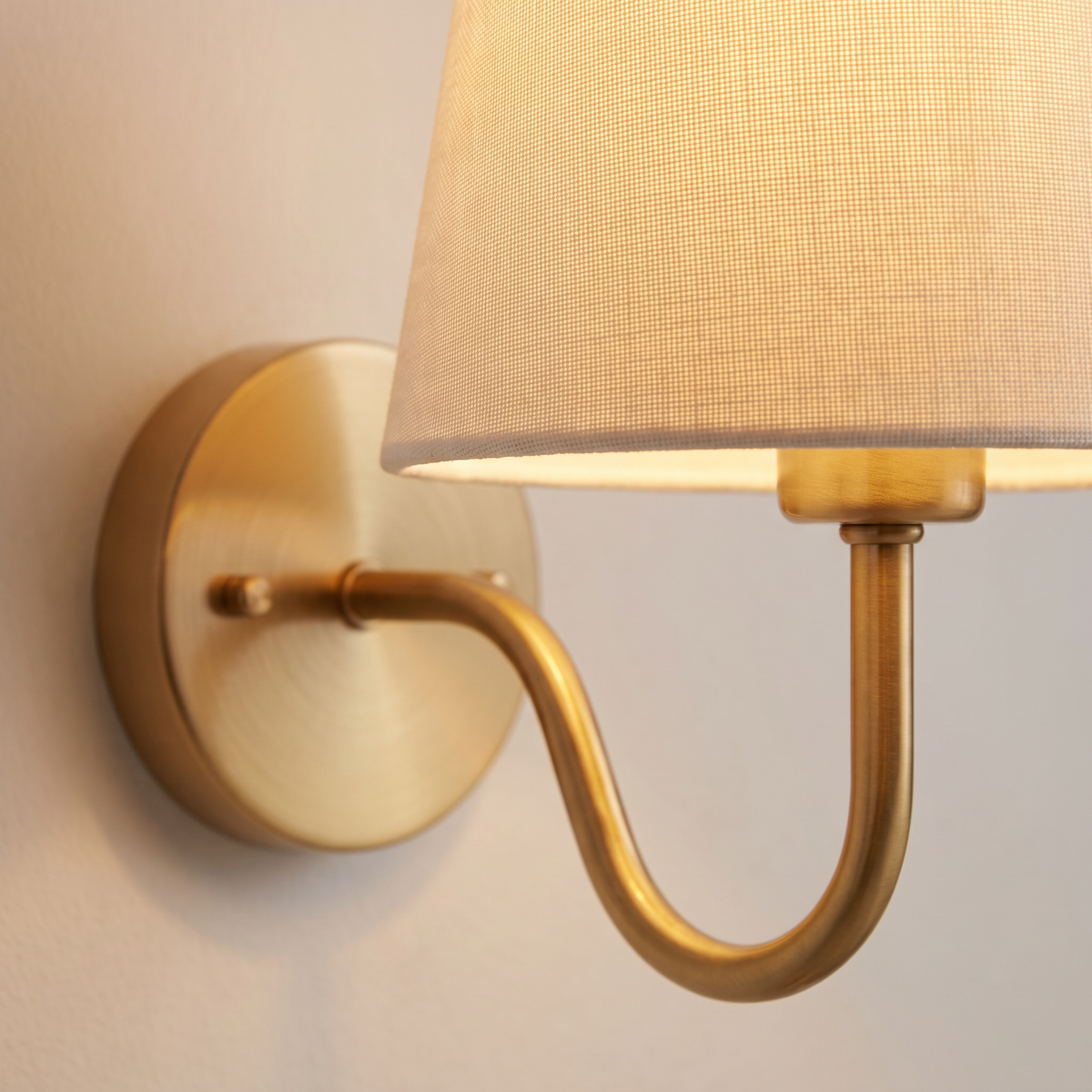 Close up of the Halcombe fabric shade and brass finish swan neck arm