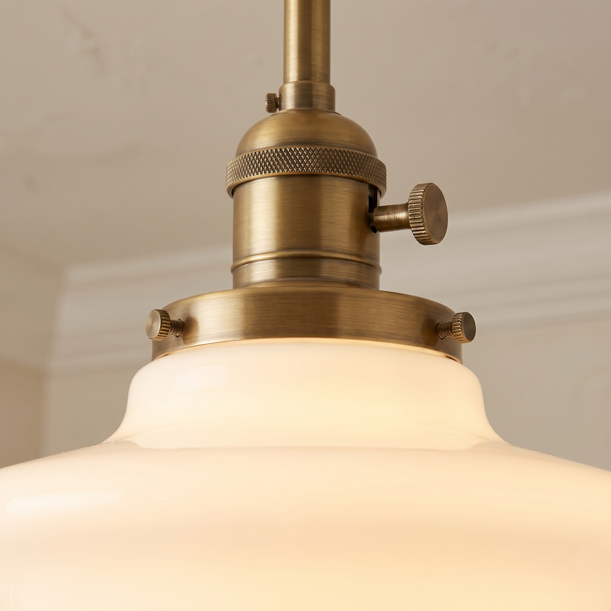 Close up of the Ely antique brass finish holder and opal milk glass shade