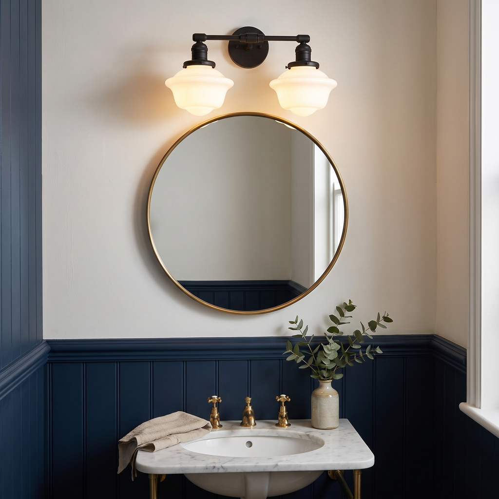 Ely two light vanity light in black above a round mirror in a cloakroom with navy panelling