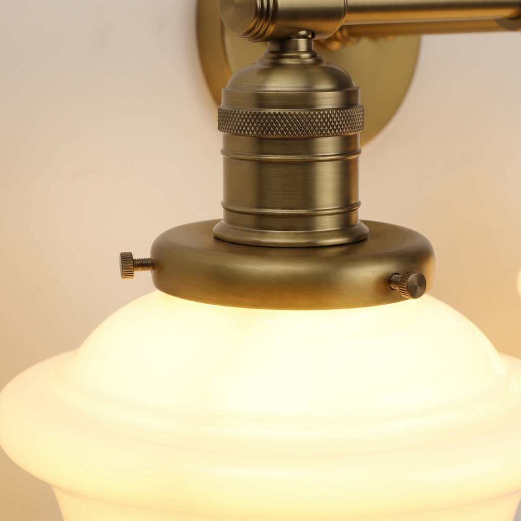 Close up of the Ely antique brass knurled lamp holder and opal milk glass shade, lit