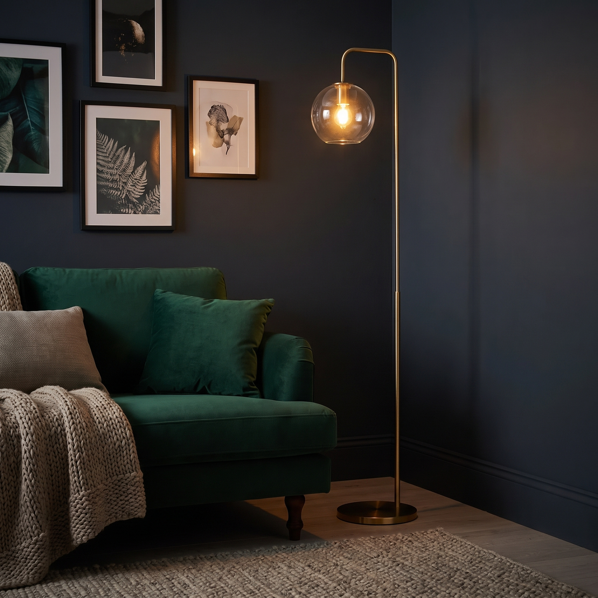 Clifton gold arc floor lamp glowing beside a green velvet sofa in a dark painted snug