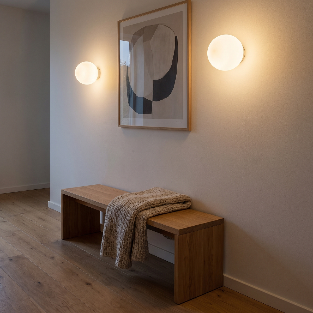 Two Aldeburgh frosted glass globe wall lights lit along a landing wall