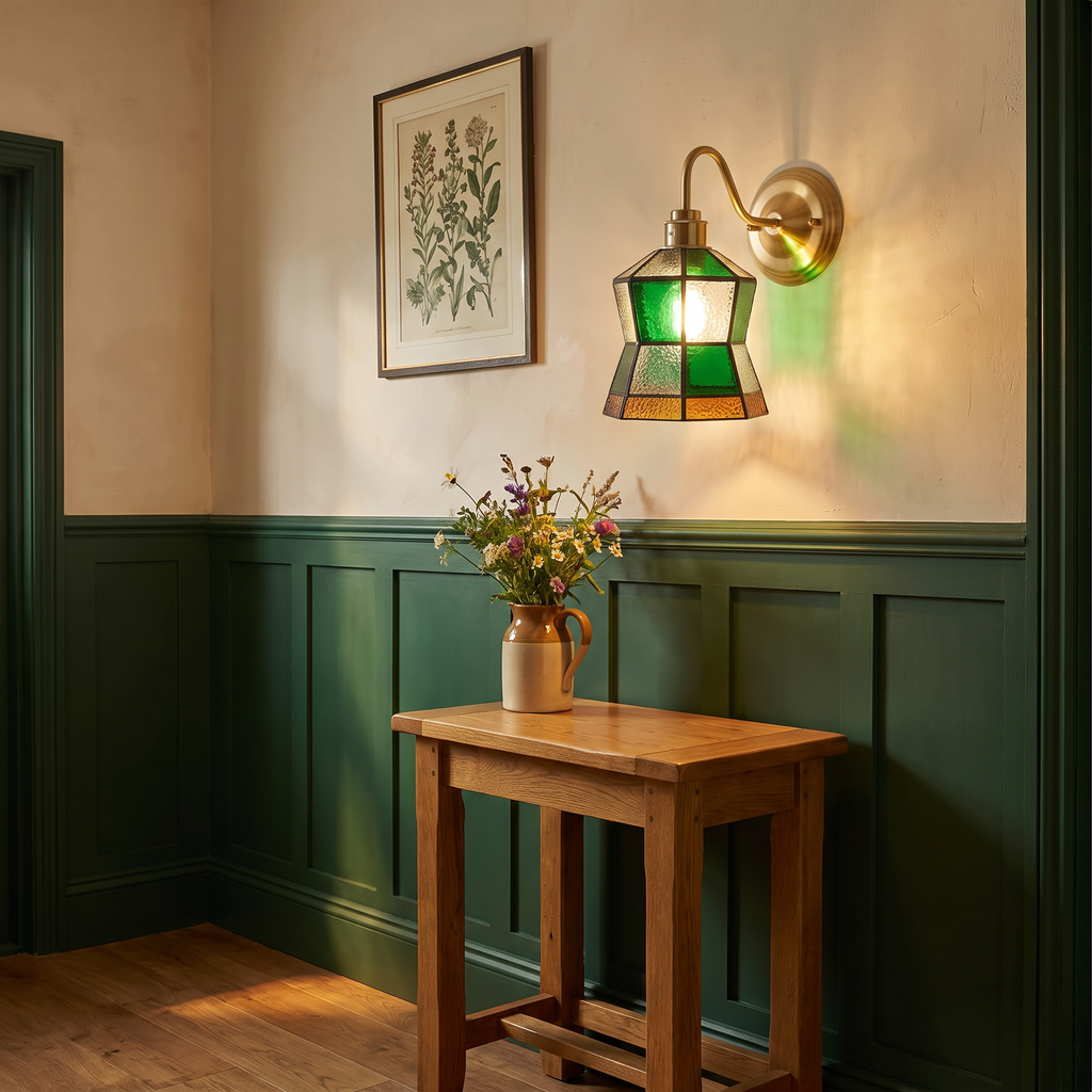 Walberswick stained glass wall light glowing above an oak console table in a green panelled hallway