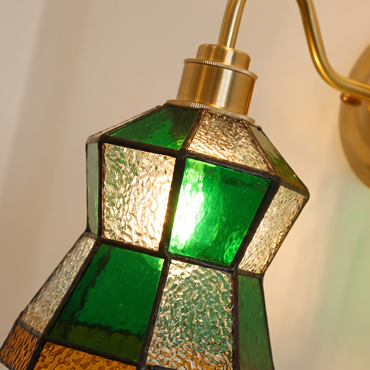 Close up of the Walberswick green, clear textured and amber leaded glass, lit
