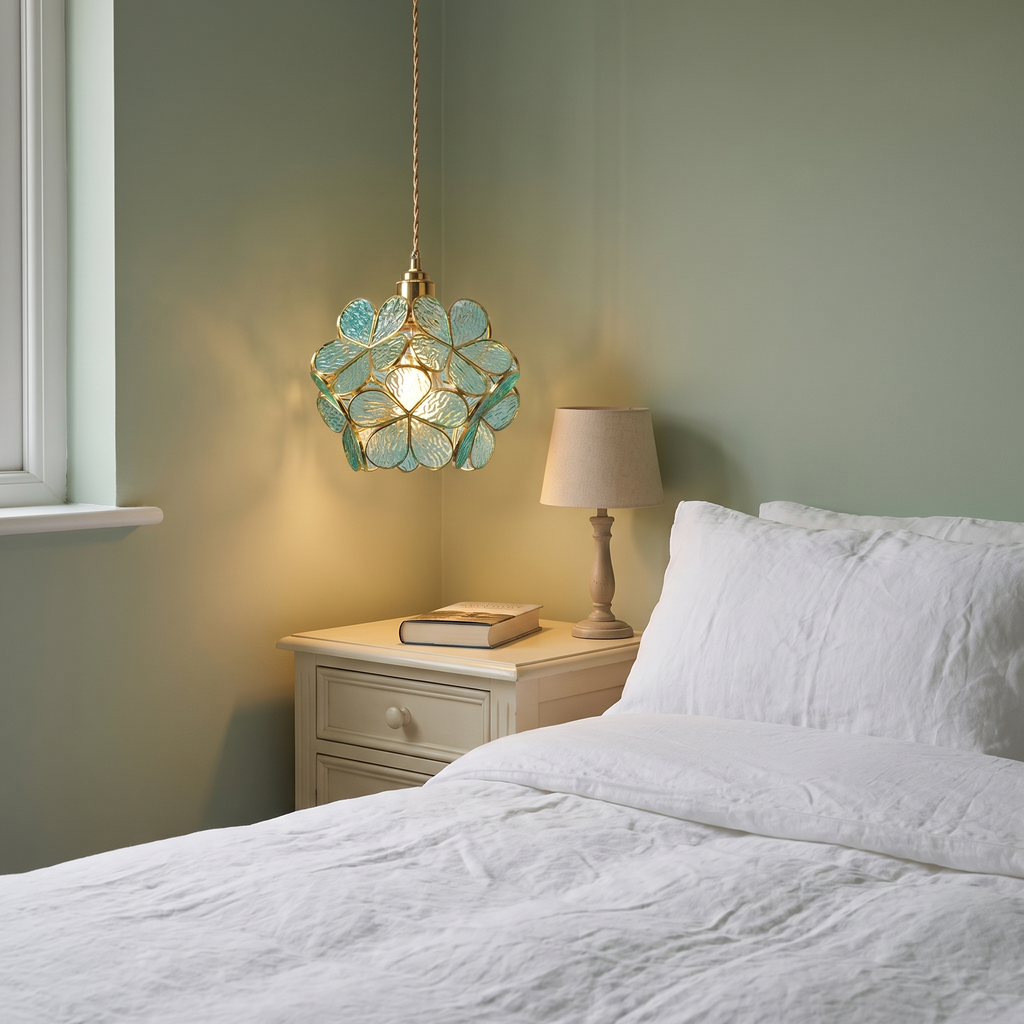 Halesworth glass petal pendant light hanging beside a bed in a sage green bedroom