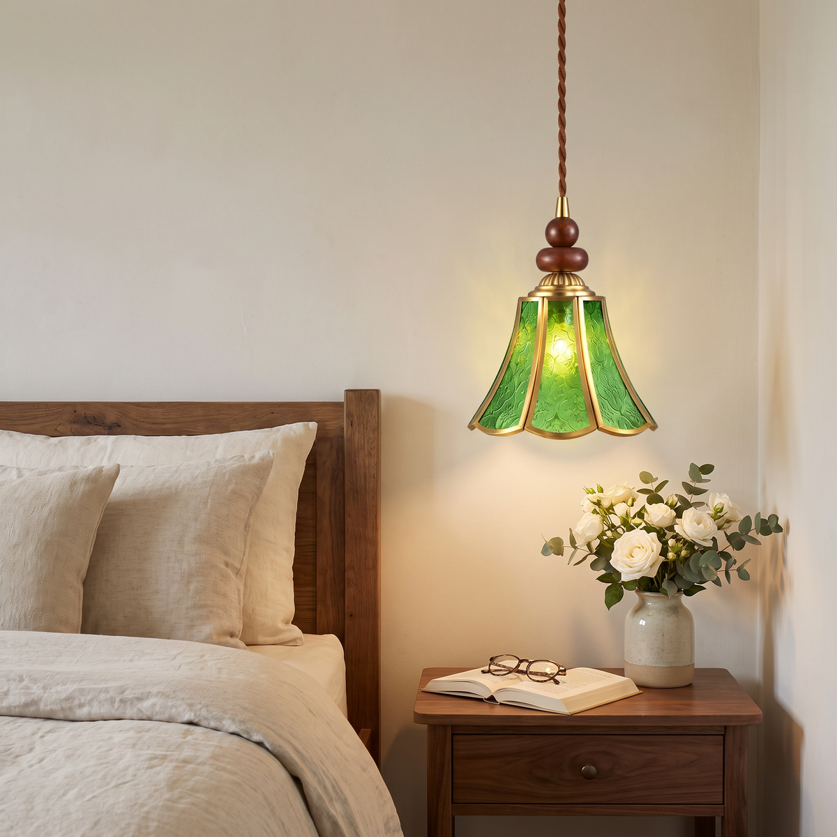 Green Yoxford embossed glass pendant light hanging beside a bed