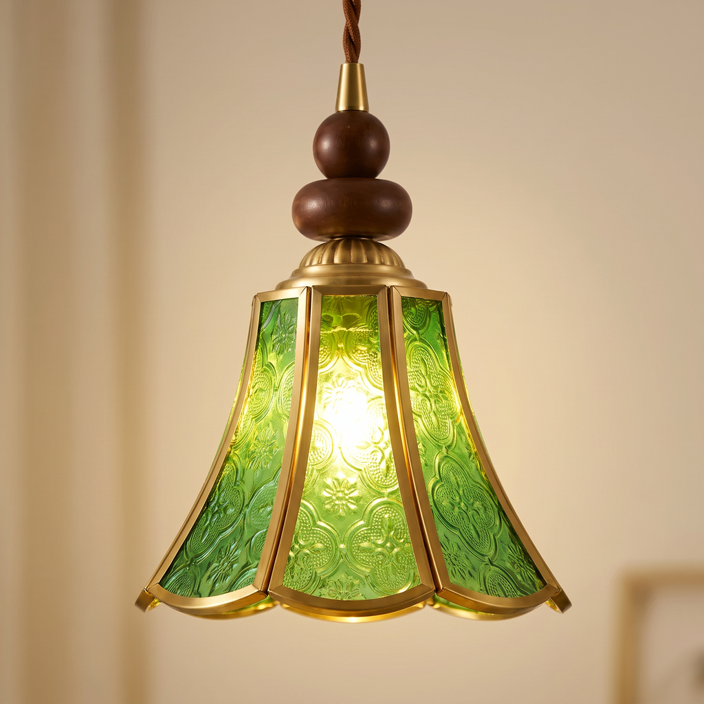 Close up of the Yoxford green embossed glass panels, brass tone ribs and walnut tone wood beads, lit