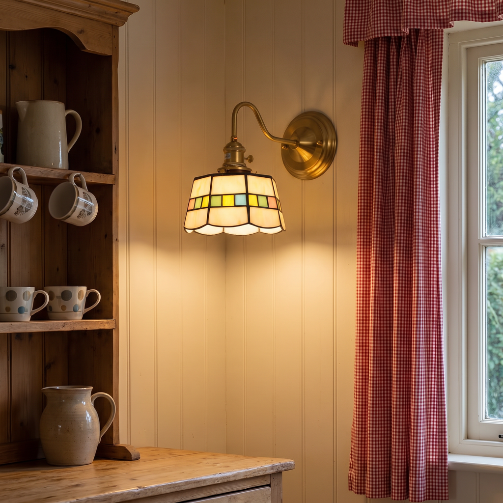 Snape stained glass wall light glowing above a dresser shelf in a cottage kitchen