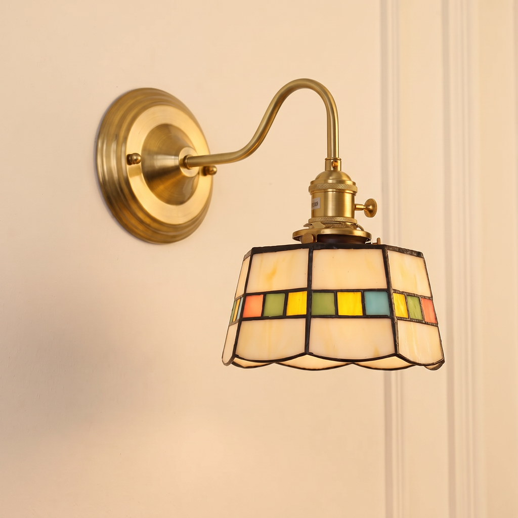 Snape geometric stained glass wall light with ivory glass and a band of coloured squares on a brass swan neck arm, lit
