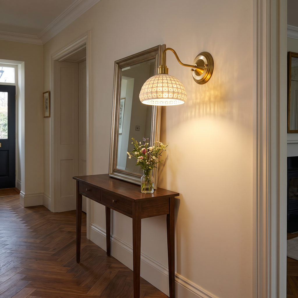 Wangford ceramic lattice wall light glowing above a hall console table