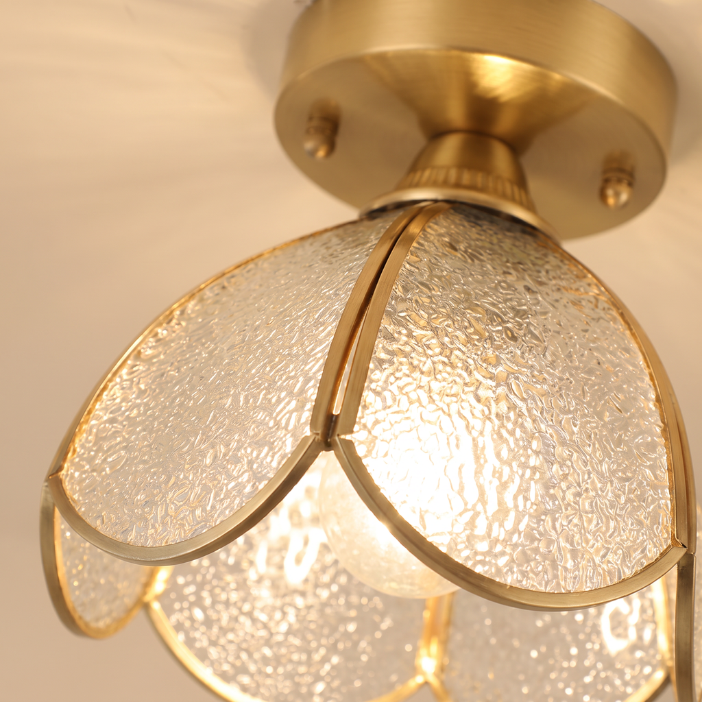 Close up of the Hadleigh clear water textured glass petals in their brass frames, lit