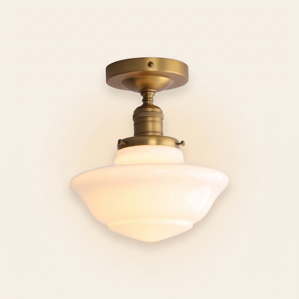 Ely milk glass semi flush ceiling light in antique brass finish, lit, on a cream background