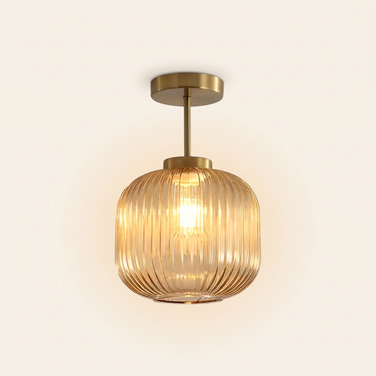 Thornbury ribbed glass semi flush ceiling light in amber, lit, on a cream background