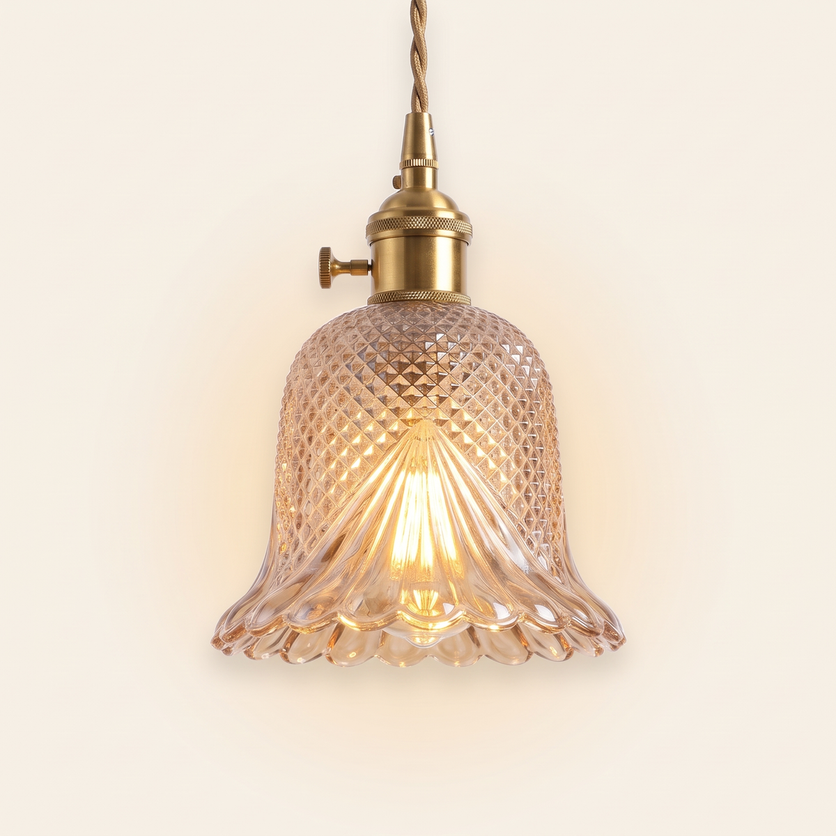 Lavenham cut glass bell pendant light in amber glass with a brass lamp holder, lit