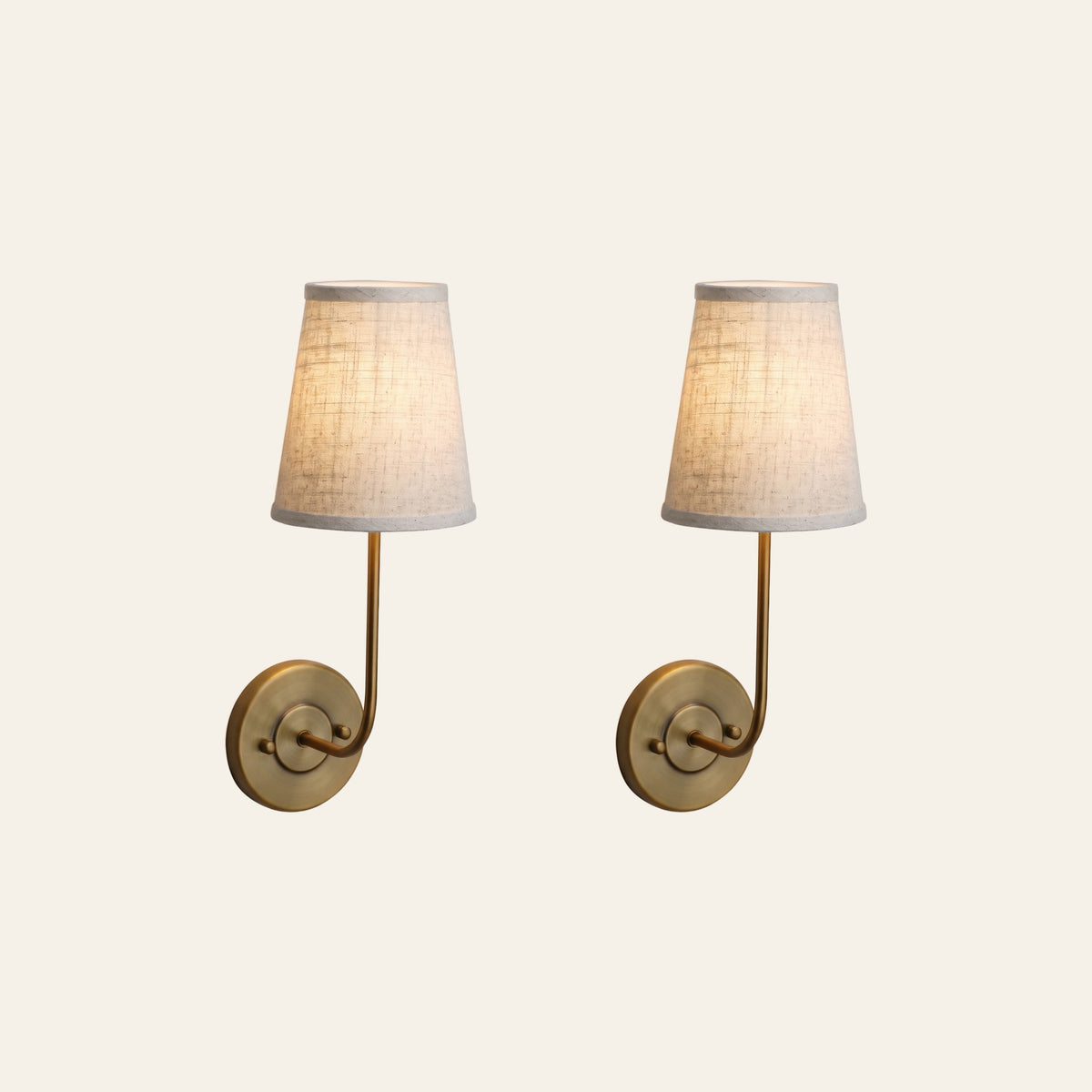 A pair of Hintlesham wall lights in antique brass with linen shades
