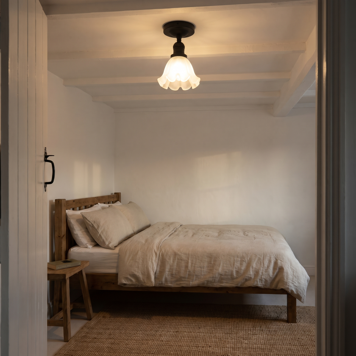 A lit black Hoxne ceiling light under a beamed ceiling in a pale cottage bedroom