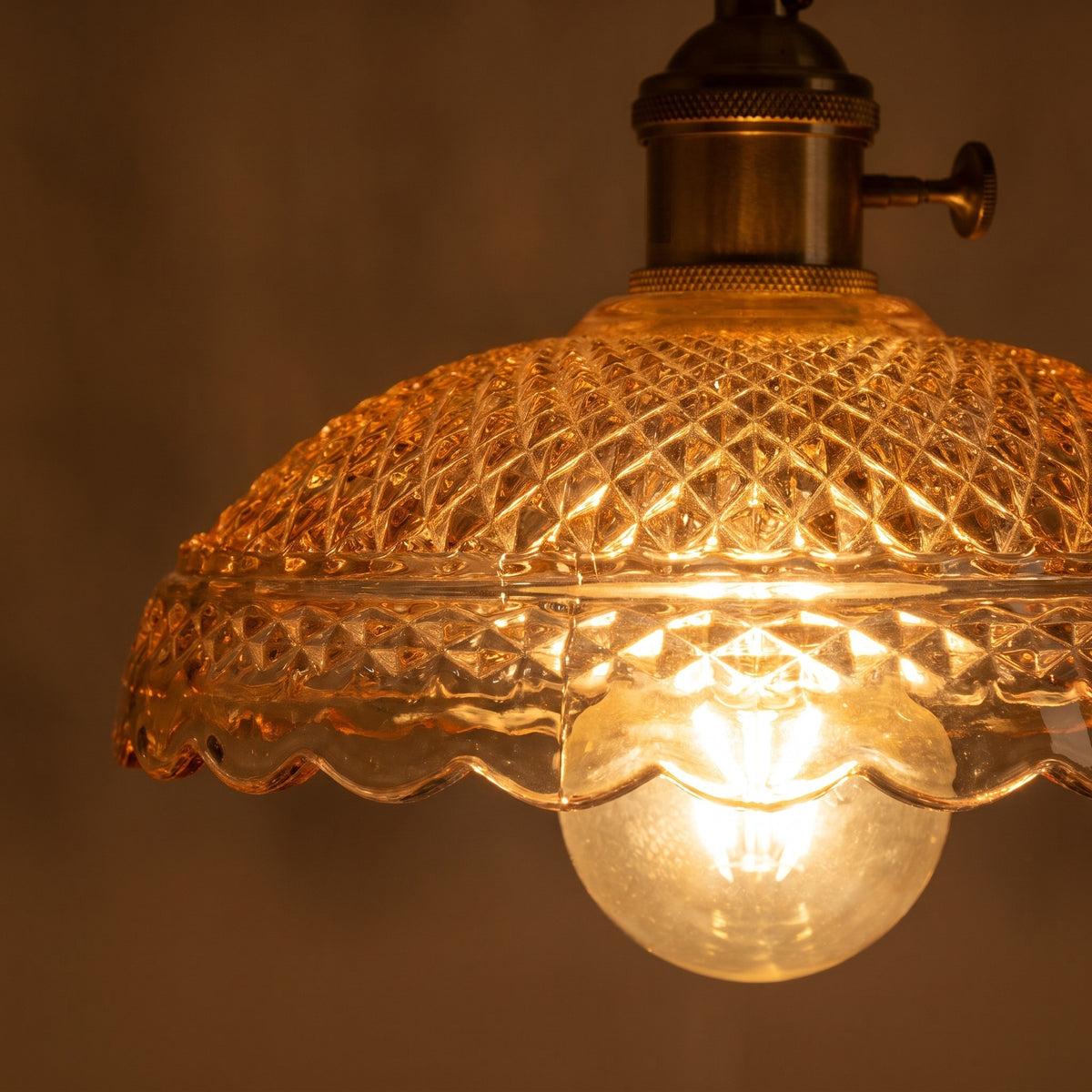 Close up of a lit Huntingfield shade showing the diamond cut pressed glass and scalloped rim