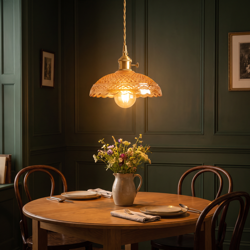 A lit Huntingfield amber pressed glass pendant over a round dining table