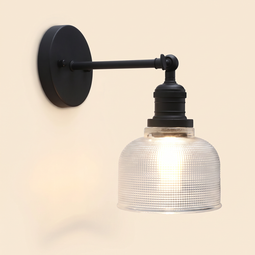 Ixworth wall light in black with a clear prismatic glass bell shade, lit, cream background