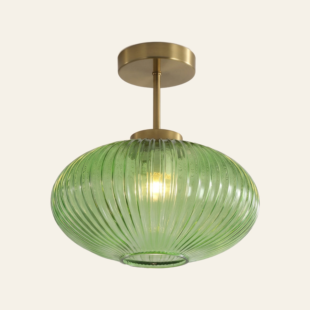 Kelsale ribbed glass semi flush ceiling light in green, 25 cm oval shade on a brass stem, cream background