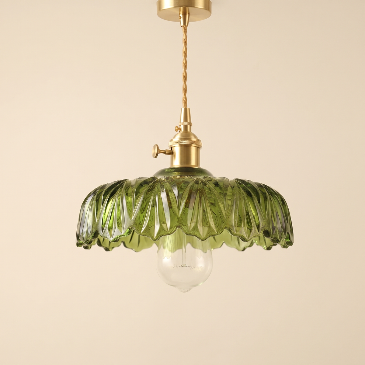 Kettleburgh pendant light with a wide green ruffled glass shade on a brass holder, cream background