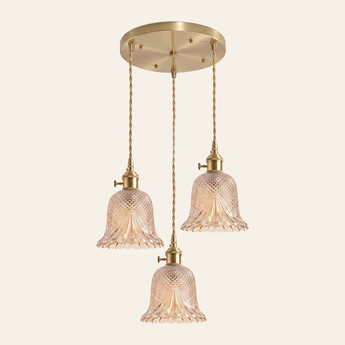 Lavenham 3 light cluster pendant with three amber cut glass bells on a round brass ceiling plate, cream background