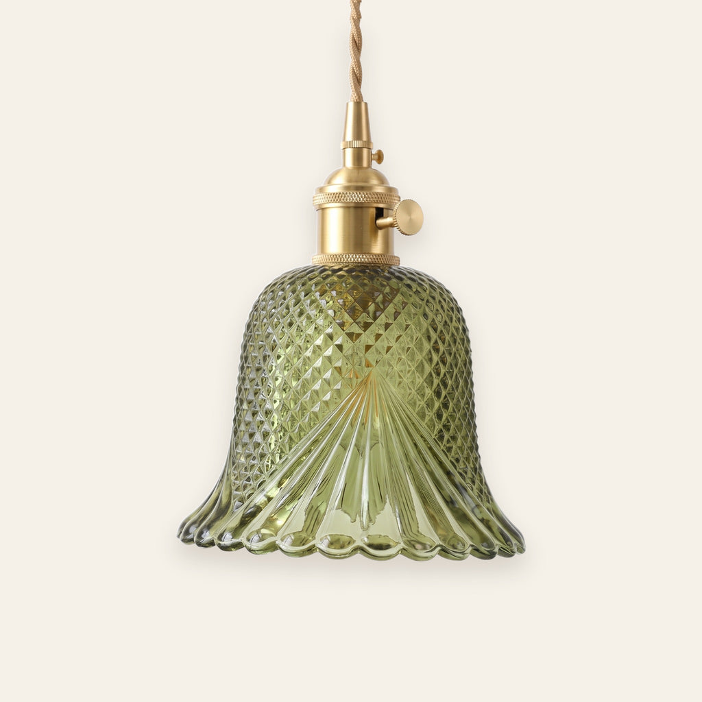 Lavenham cut glass bell pendant light in green glass with a brass lamp holder on a cream background