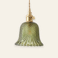 Lavenham cut glass bell pendant light in green glass with a brass lamp holder on a cream background