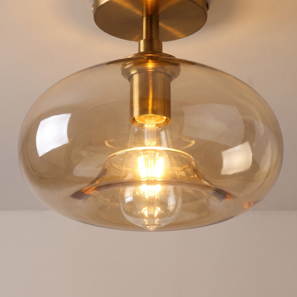 Close up of a lit Mendham shade showing the clear amber glass, the curved rim and the filament bulb inside