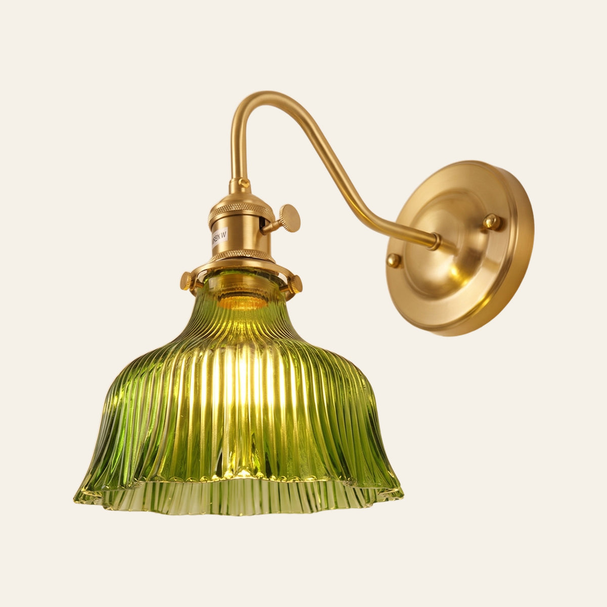 Nayland wall light with a fluted green glass bell shade on a brass swan neck arm, lit