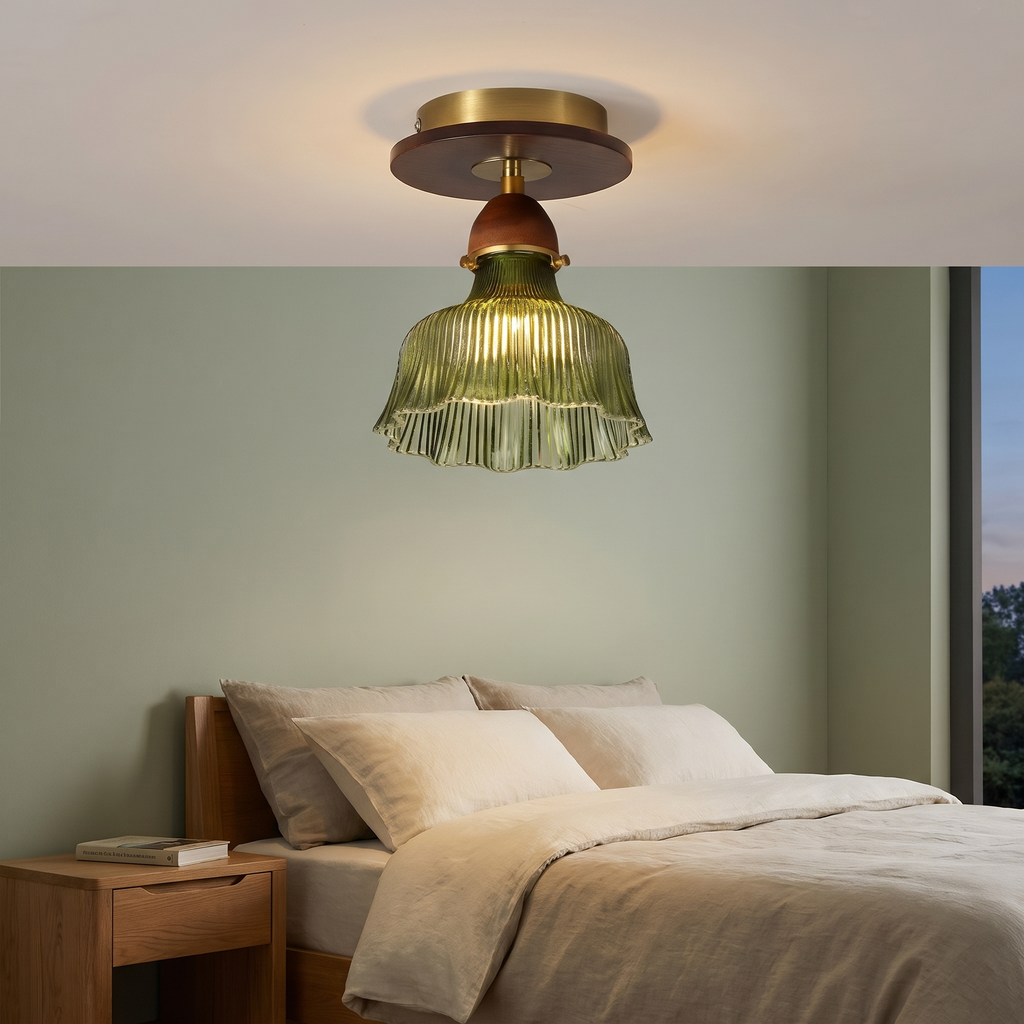 A lit Nayland green glass semi flush ceiling light in a calm bedroom with sage green walls