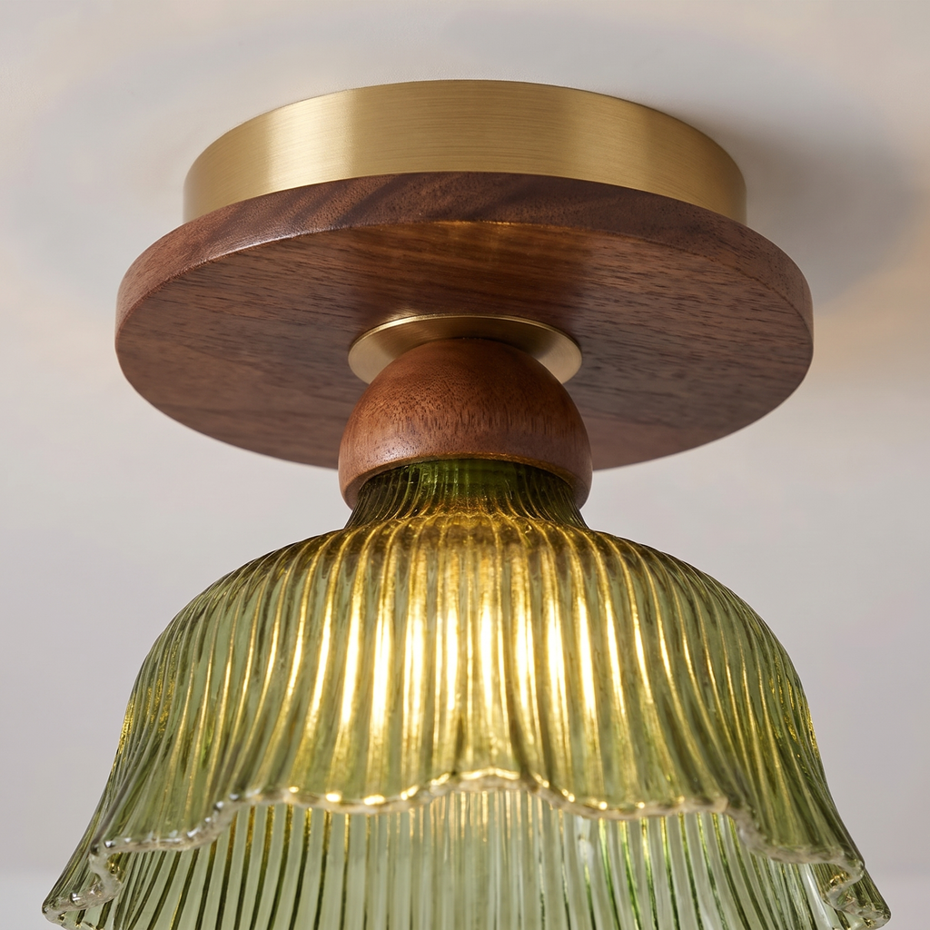 Close up of the Nayland semi flush: brass ceiling plate, walnut tone wood disc and neck, and the ribbed green glass glowing