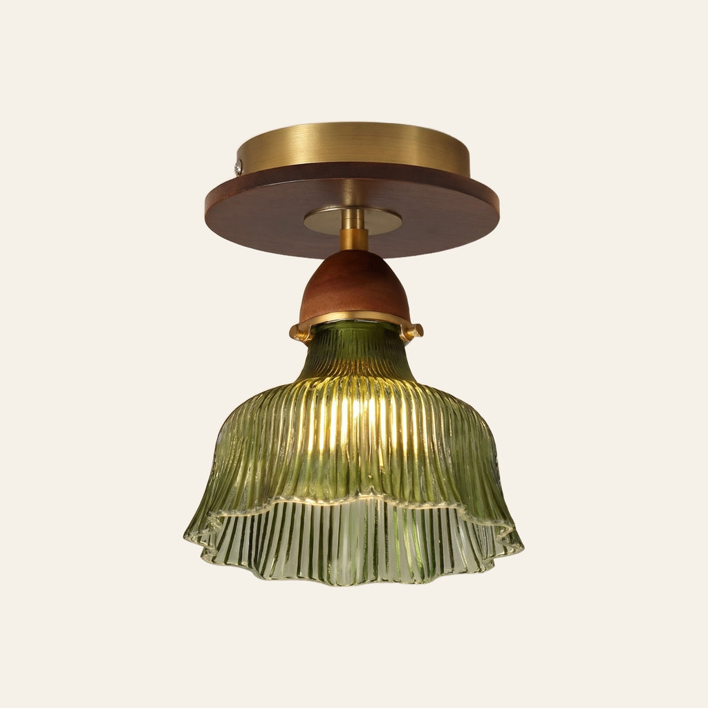 Nayland semi flush ceiling light, a green fluted glass bell with a scalloped rim on a walnut tone neck and a brass ceiling plate, lit, cream background