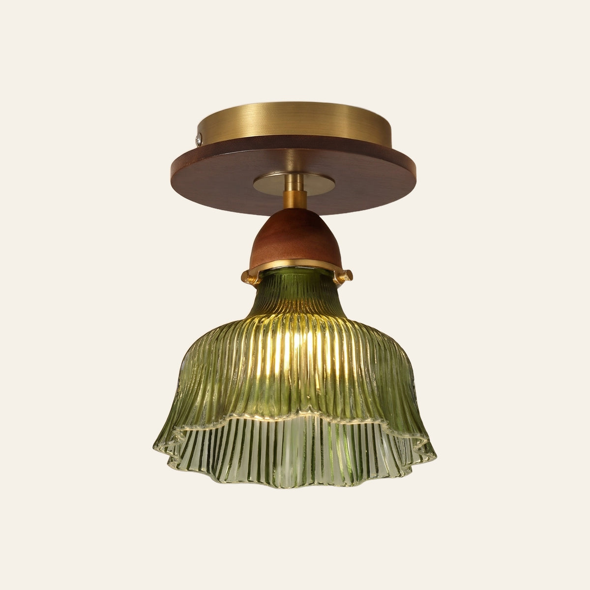 Nayland semi flush ceiling light, a green fluted glass bell with a scalloped rim on a walnut tone neck and a brass ceiling plate, lit, cream background