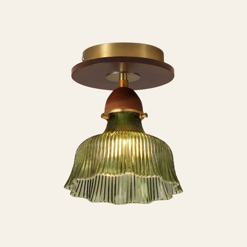Nayland semi flush ceiling light, a green fluted glass bell with a scalloped rim on a walnut tone neck and a brass ceiling plate, lit, cream background