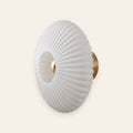 Ondine pleated opal glass wall light with brass plate, cream background