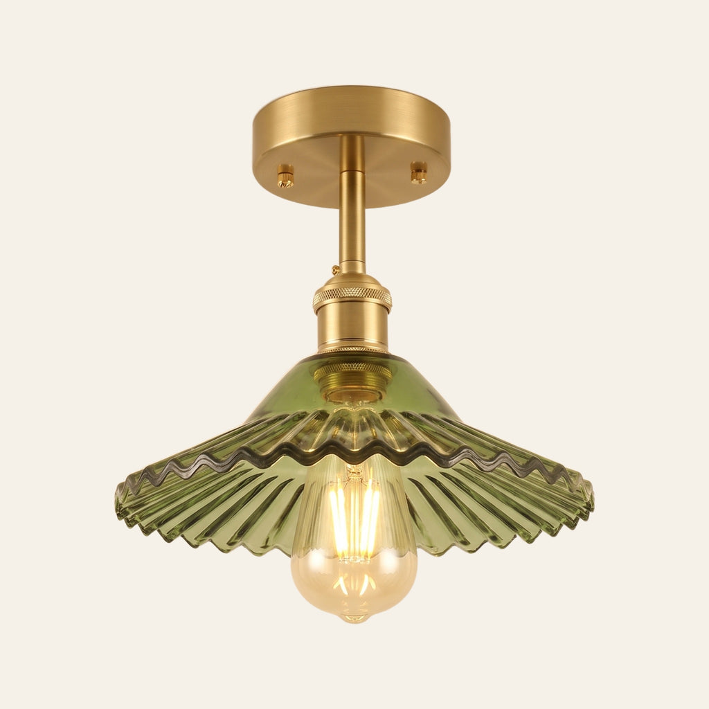 Peasenhall ceiling light with a green pleated glass cone shade on a brass rod and an exposed filament bulb, lit