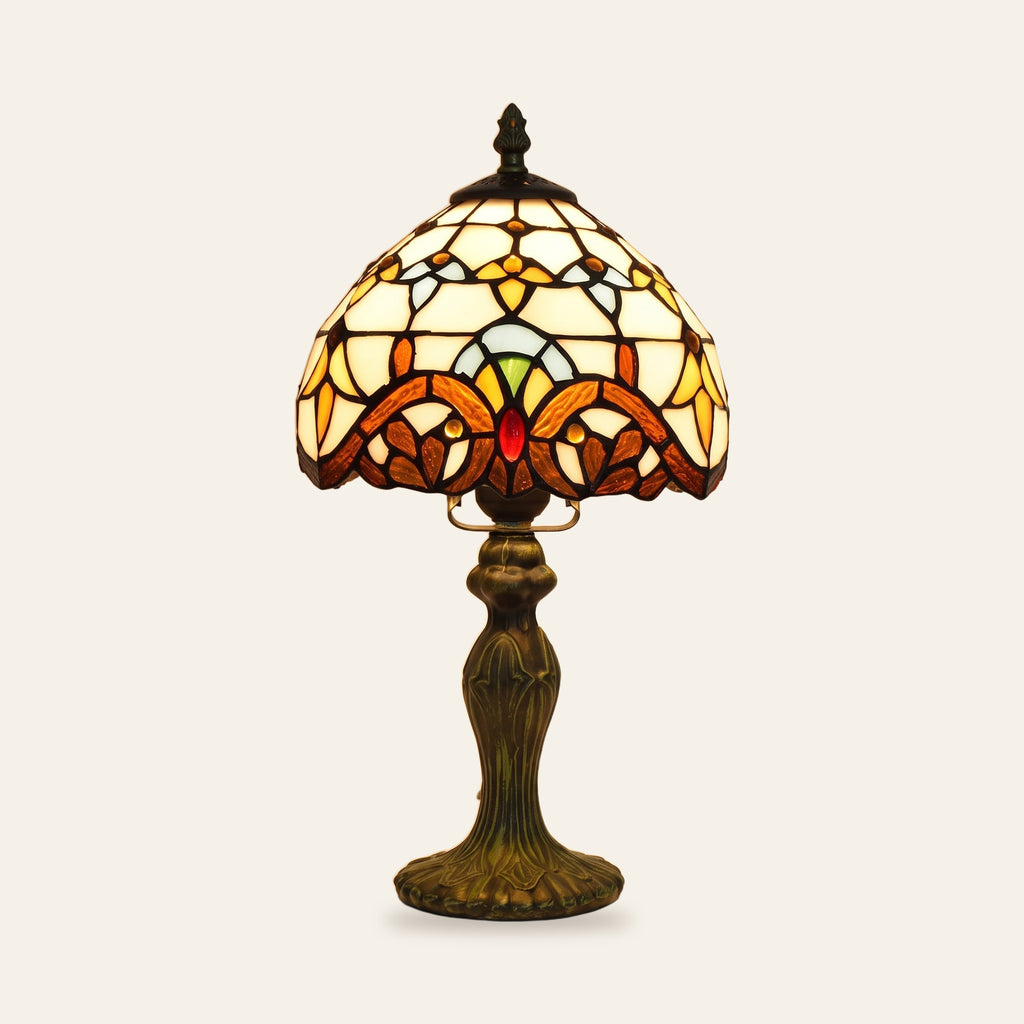 Polstead stained glass table lamp with a cream leaded shade and an amber and burgundy baroque band on a bronze finish base, cream background