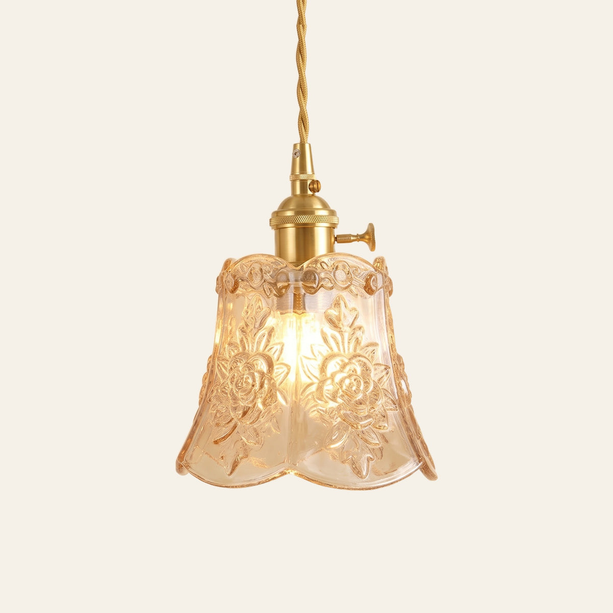Rendham rose glass pendant light: honey amber pressed glass bell embossed with roses on a brass holder, cream background