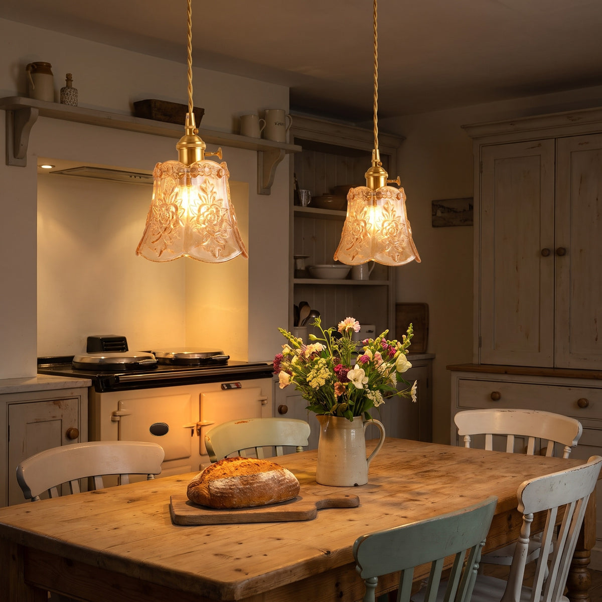 Two amber Rendham rose glass pendants lit over a farmhouse kitchen table
