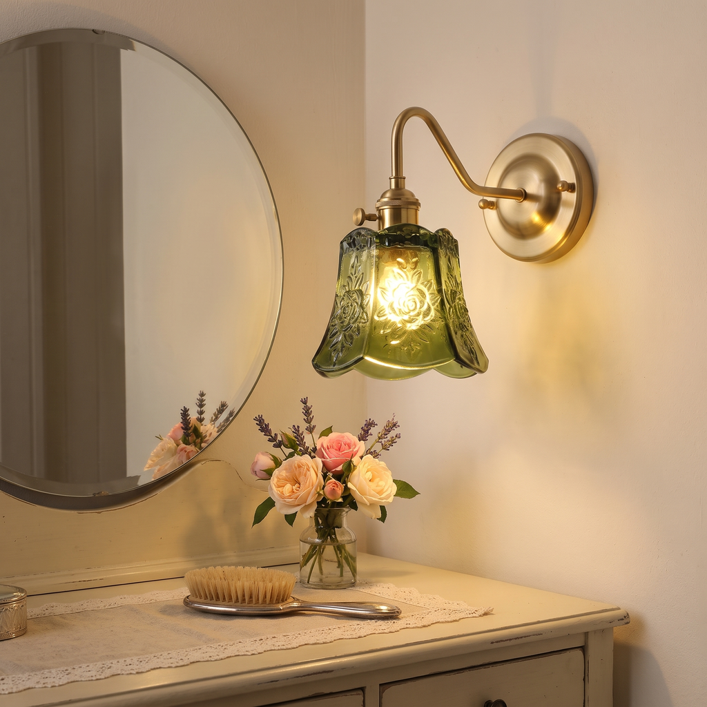 Green Rendham rose glass wall light lit beside a mirror over a dressing table