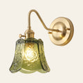 Rendham rose glass wall light: olive green pressed glass bell embossed with roses on a brass swan neck arm, cream background