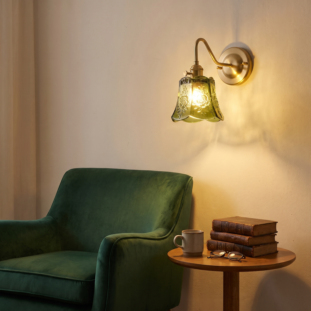 Green Rendham rose glass wall light lit above a velvet reading chair