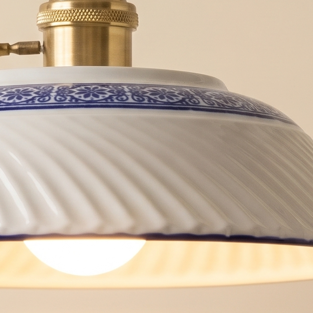 Close up of the swirled ribs and cobalt blue and white band of the Reydon porcelain shade and its brass finish holder