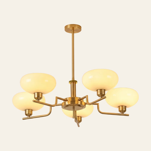 Saxmundham chandelier with five curved gold finish arms and upturned cream opal glass shades, lit, cream background