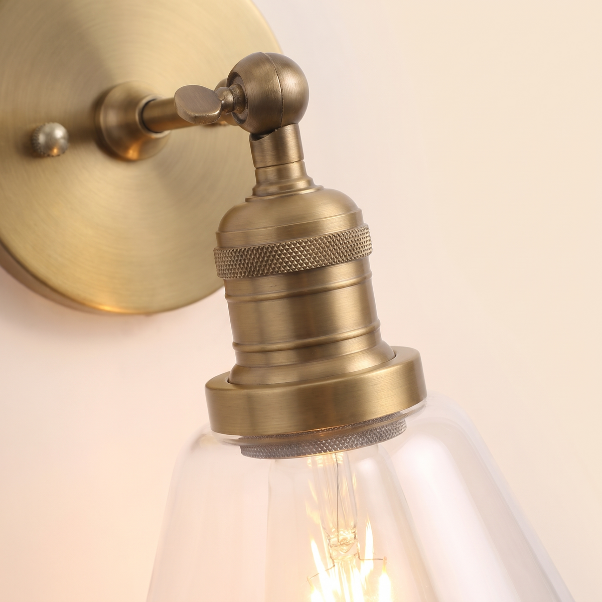 Close up of the Shotley knurled antique brass holder and clear glass cone, lit
