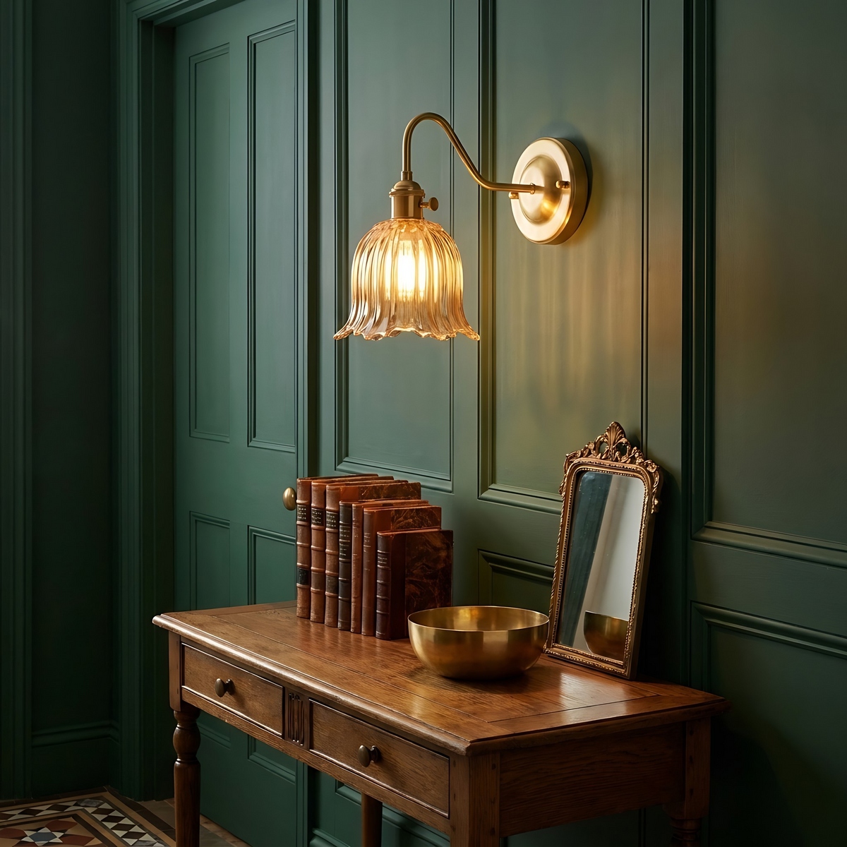 Amber Sibton wall light glowing above an oak console table in a green panelled hallway