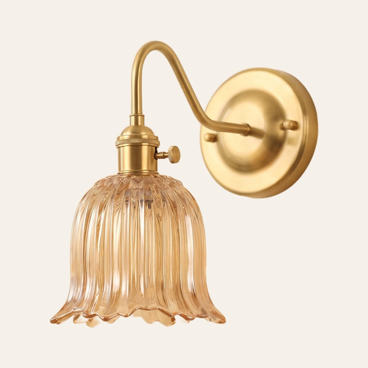 Sibton wall light with an amber fluted tulip glass bell on a brass swan neck arm, cream background