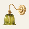 Sibton wall light with a green fluted tulip glass bell on a brass swan neck arm, cream background