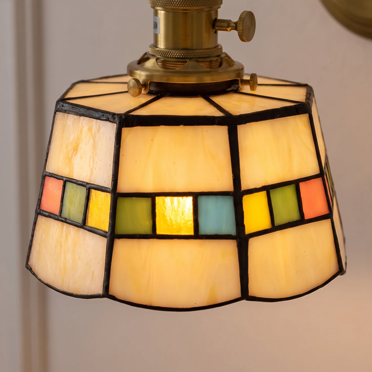 Close up of the Snape ivory glass panels and coloured squares in dark leading, lit